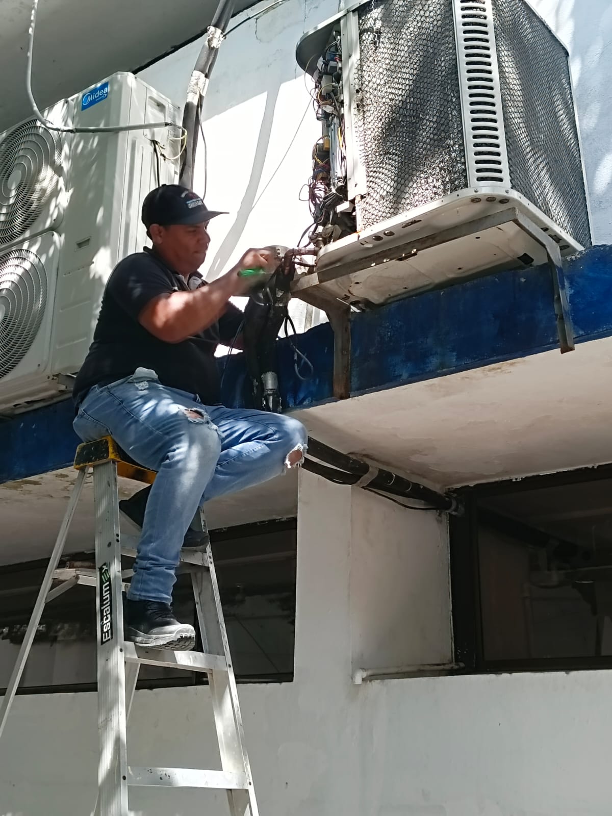 Técnico Chrisdayk reparando unidad exterior de aire acondicionado